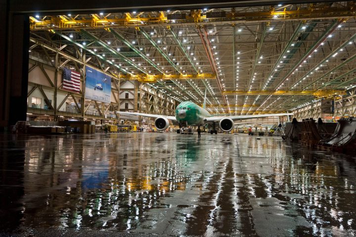 reflective photo of a jumbo jet in a hangar at boeing factory