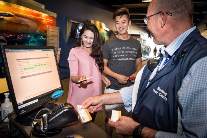 happy people scanning their tickets to see the future of flight on a boeing factory tour