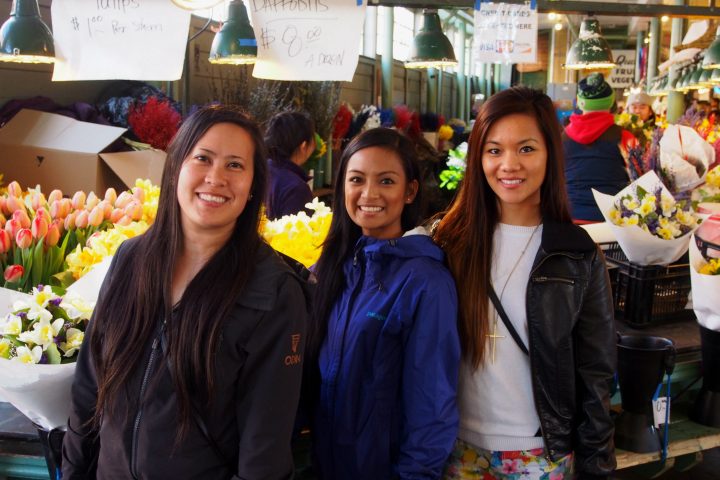 Antoinette Jadaone et al. standing in front of a store at the market on a seattle day tour