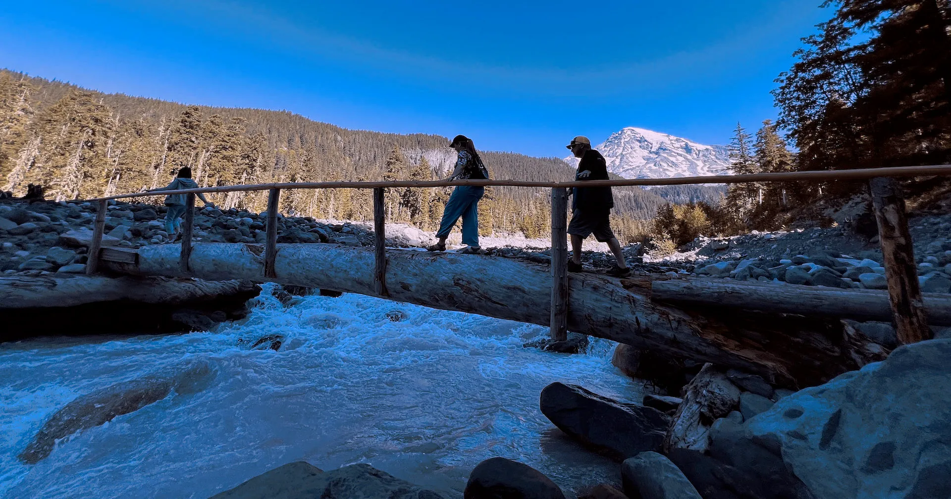 a man standing on top of a snow covered bridge