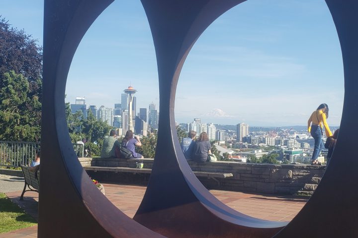 a close up of a public art sculpture with the Seattle skyline in the background on a private tour