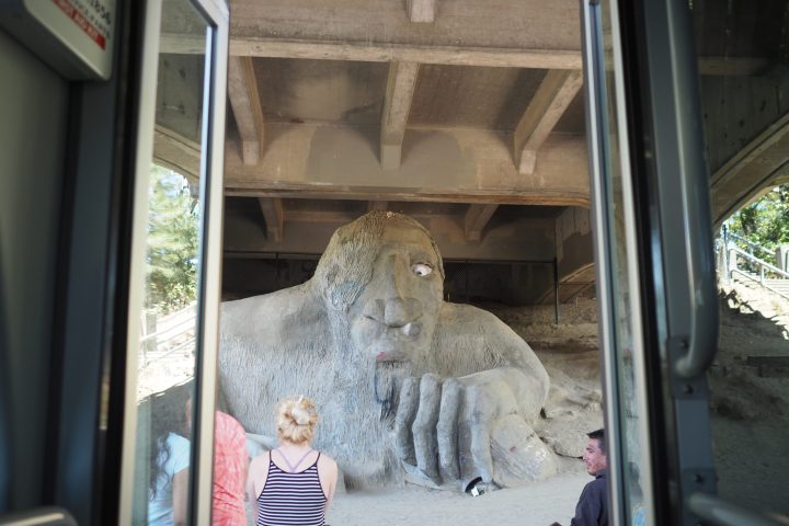 people standing in front of Fremont Troll under bridge