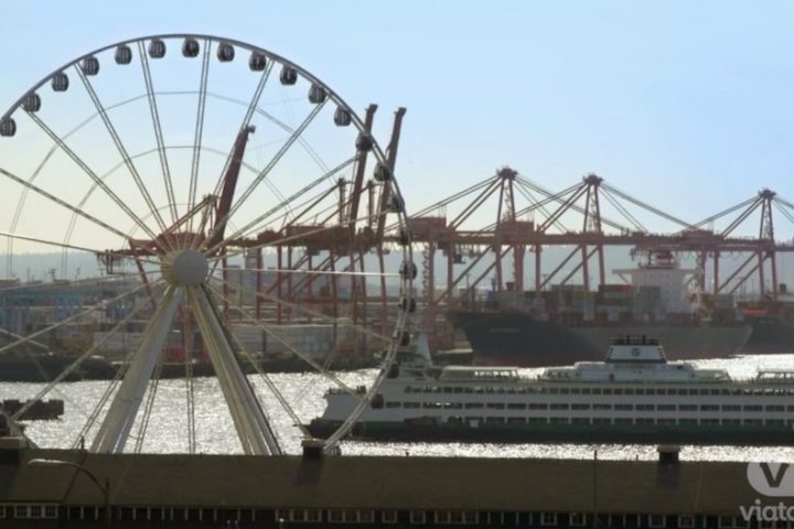a large ferry on the water and a ferris wheel in Seattle on the Pre-Cruise Tour