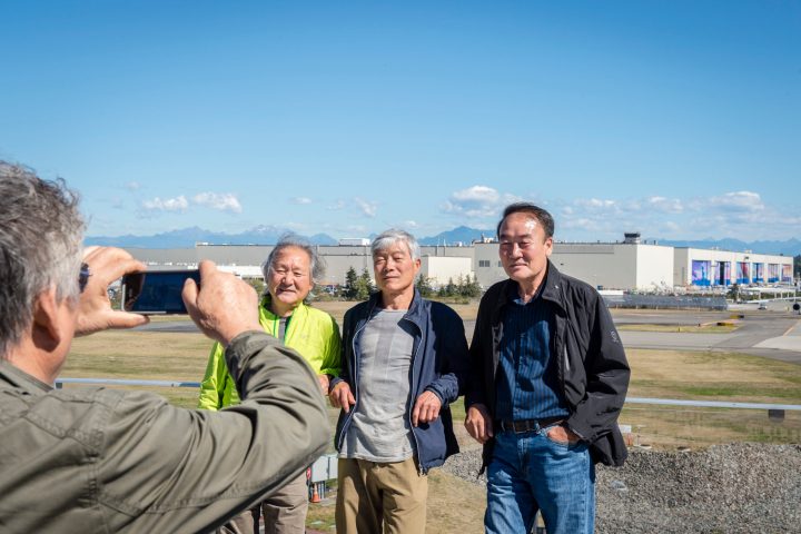 people getting their photo taken in front of boeing facility