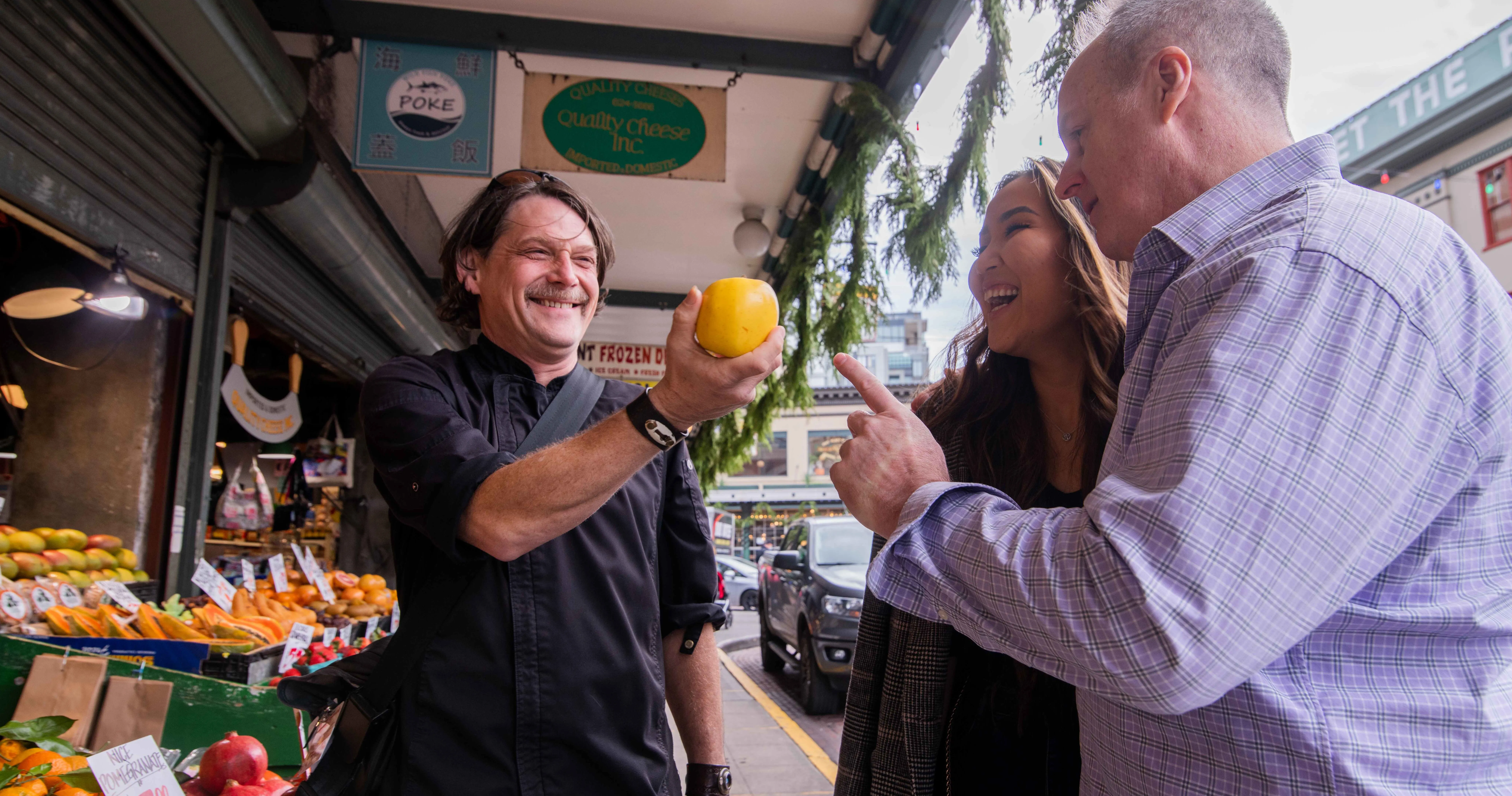 a man standing in front of a fruit stand