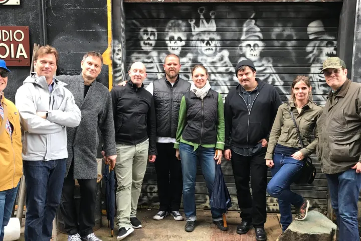 Claus Meyer et al. standing in front of a graffiti wall while exploring seattle
