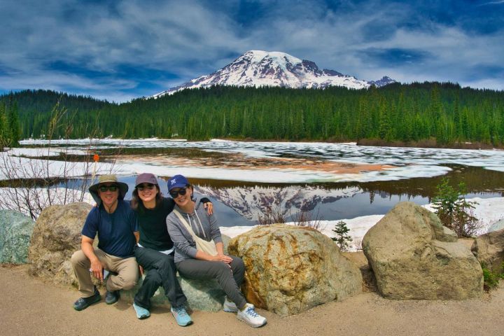 a group of people sitting in front of Mt. Rainier and Reflection Lake