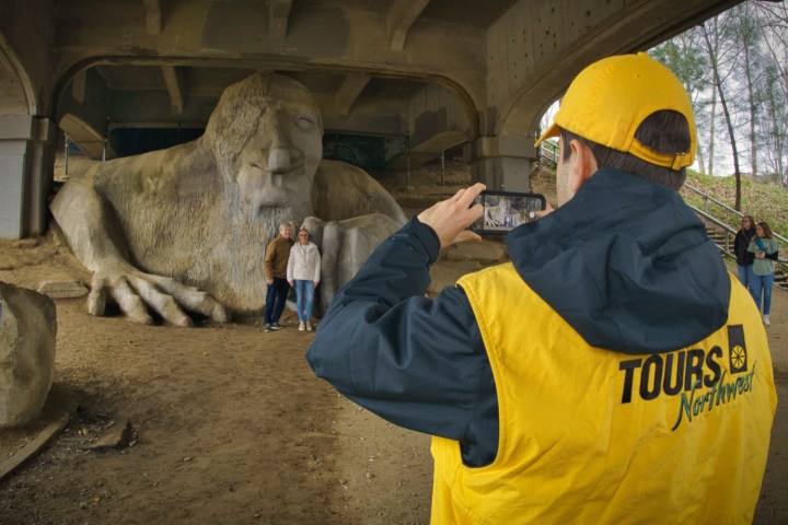 a tour guide taking picture of Fremont Troll during walking tours in Seattle