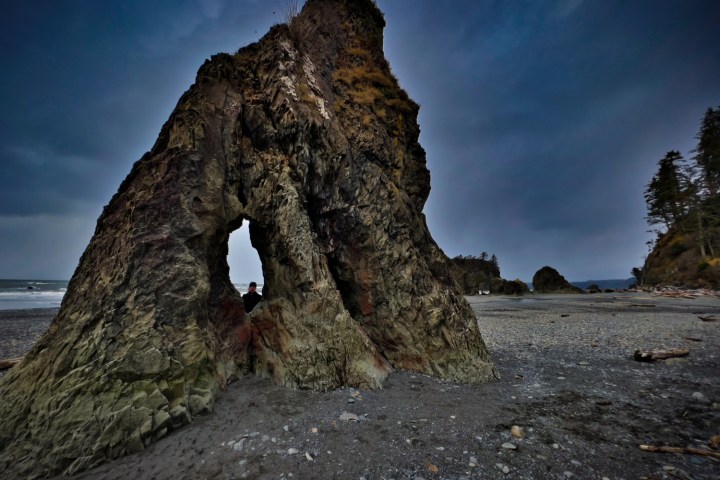 a rocky mountain with trees in the background