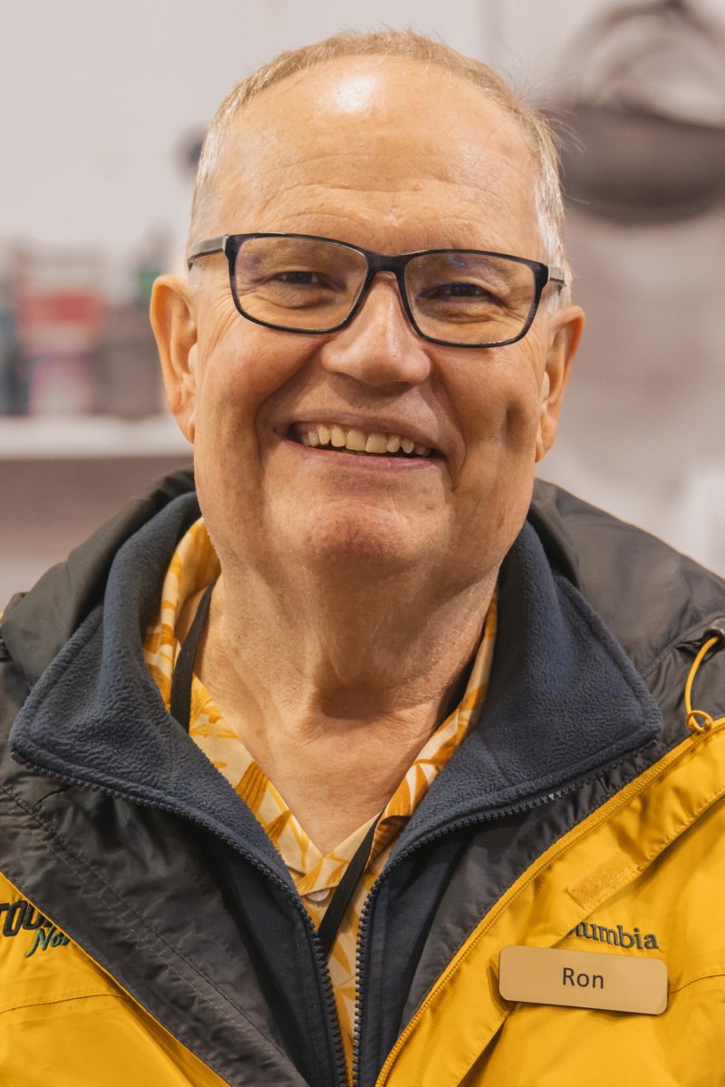 a tours northwest tour guide wearing glasses and smiling at the camera
