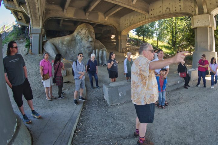 a group of people standing in front of the Fremont Troll on a Seattle Walking Tour