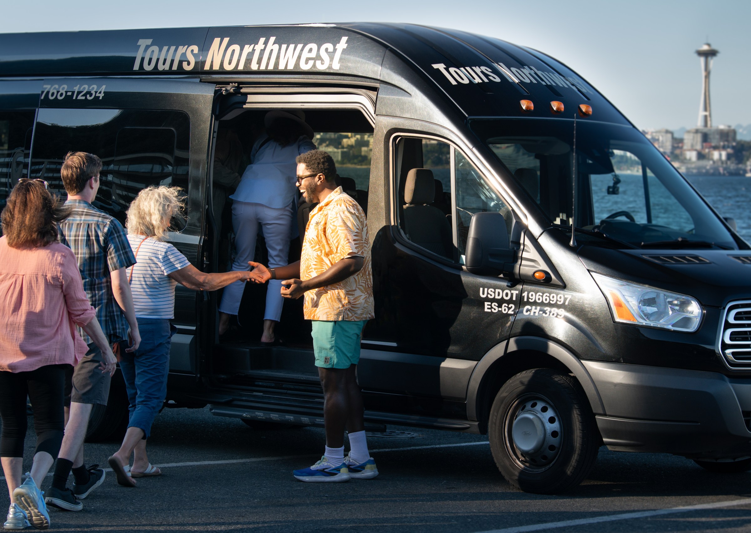 Tours Northwest guide helping guests onto the vehicle in Seattle