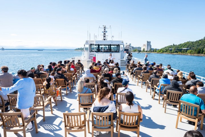 a group of people on the deck of the Argosy Harbor Cruise boat exploring Seattle by sea during a land and sea tour